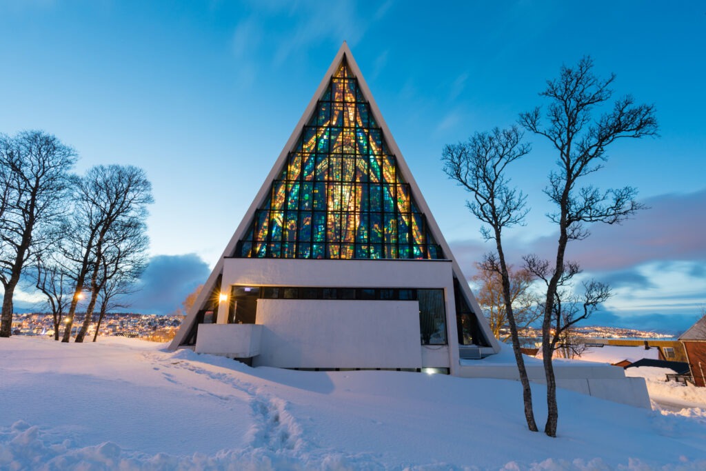 Die Eismeerkathedrale in Tromsø, Norwegen, beleuchtet in der Dämmerung.