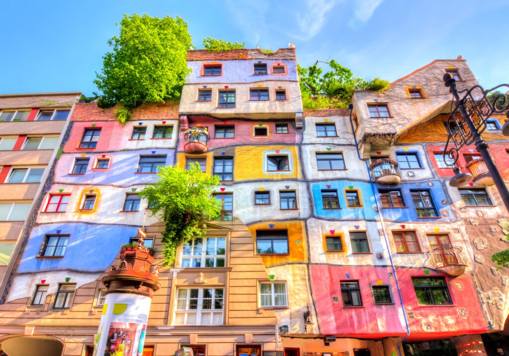 Das Hundertwasserhaus in Wien, ein farbenfrohes, unkonventionelles Gebäude mit organischen Formen, begrünten Fassaden und verspielter Architektur.