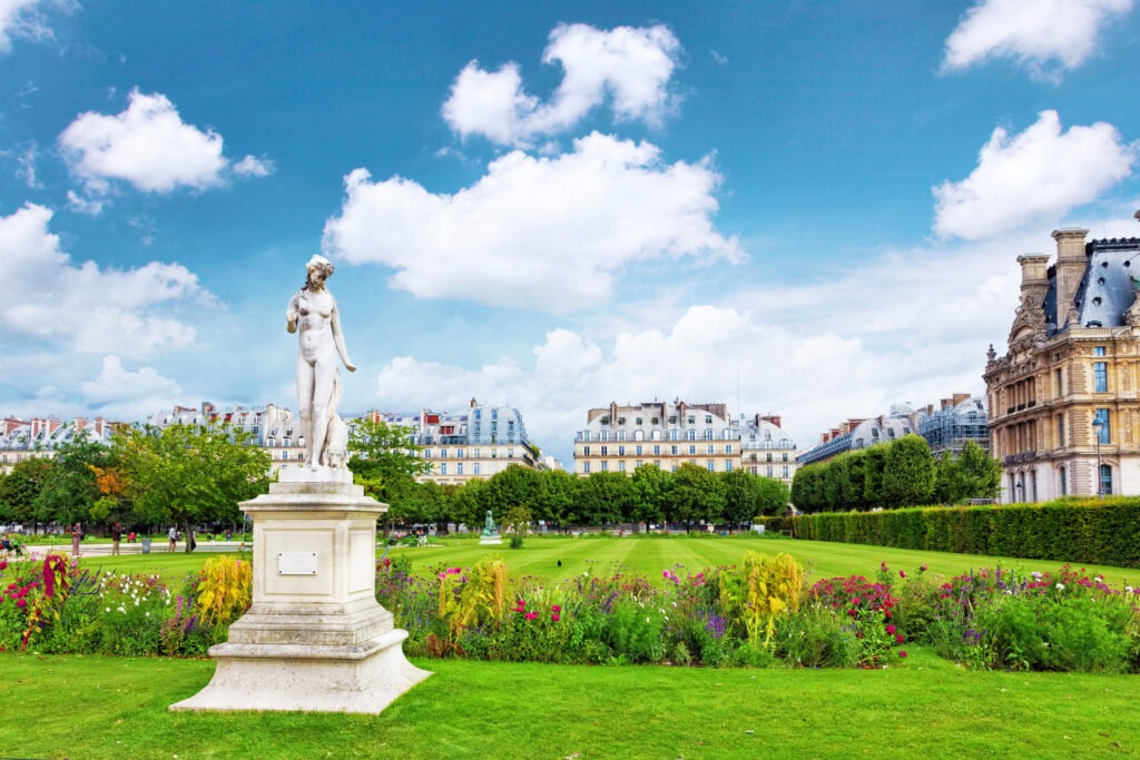 Skulpturen und Statuen im Tuileriengarten in Paris, umgeben von gepflegten Grünflächen und blühenden Beeten in einer eleganten Parklandschaft.