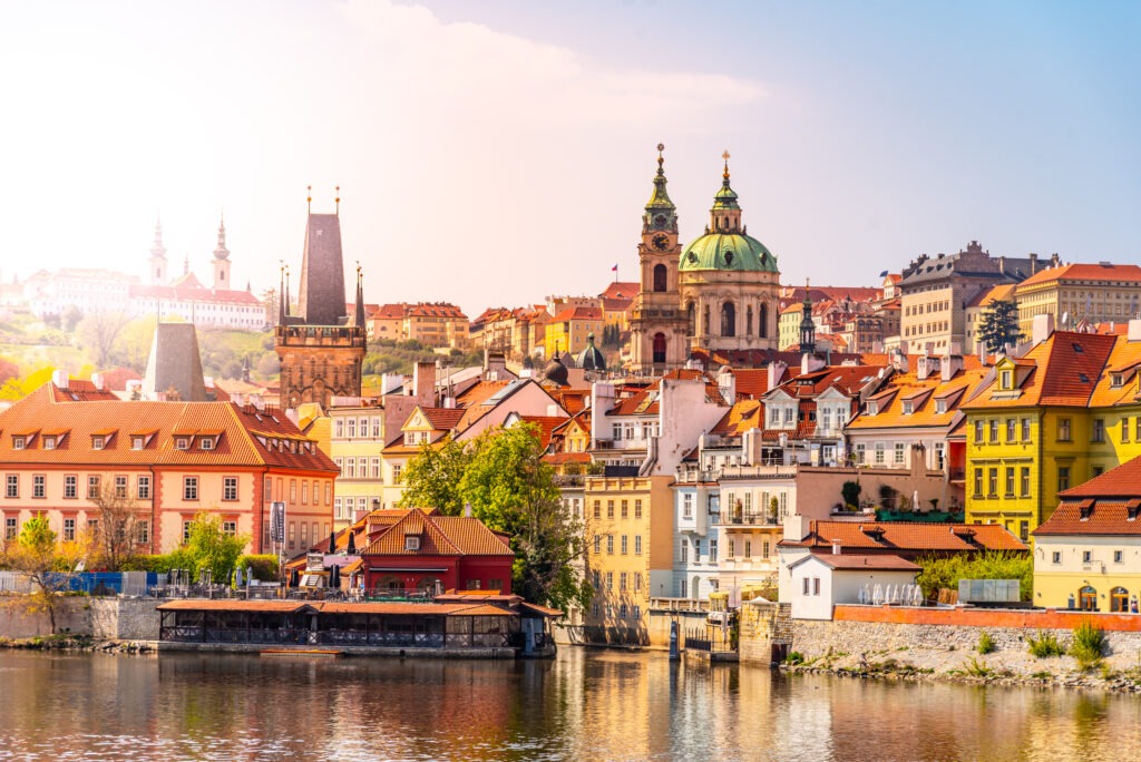 Blick auf die Prager Kleinseite (Malá Strana) mit ihren historischen Gebäuden, roten Ziegeldächern und engen Gassen, umgeben von einer malerischen Kulisse in Prag, Tschechien.