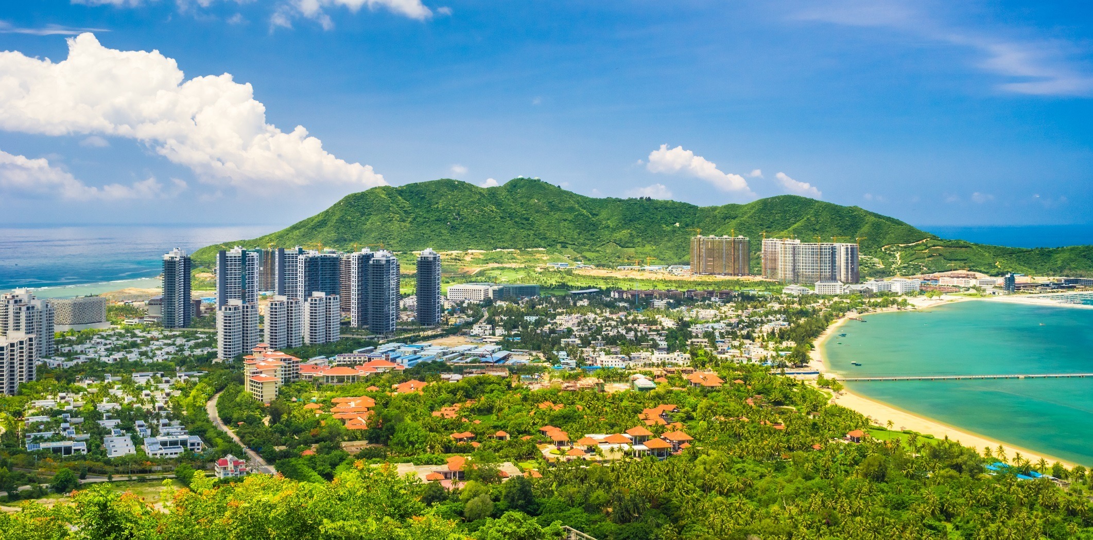 Panorama von Sanya, Hainan, China, mit Strand und Hochhäusern.