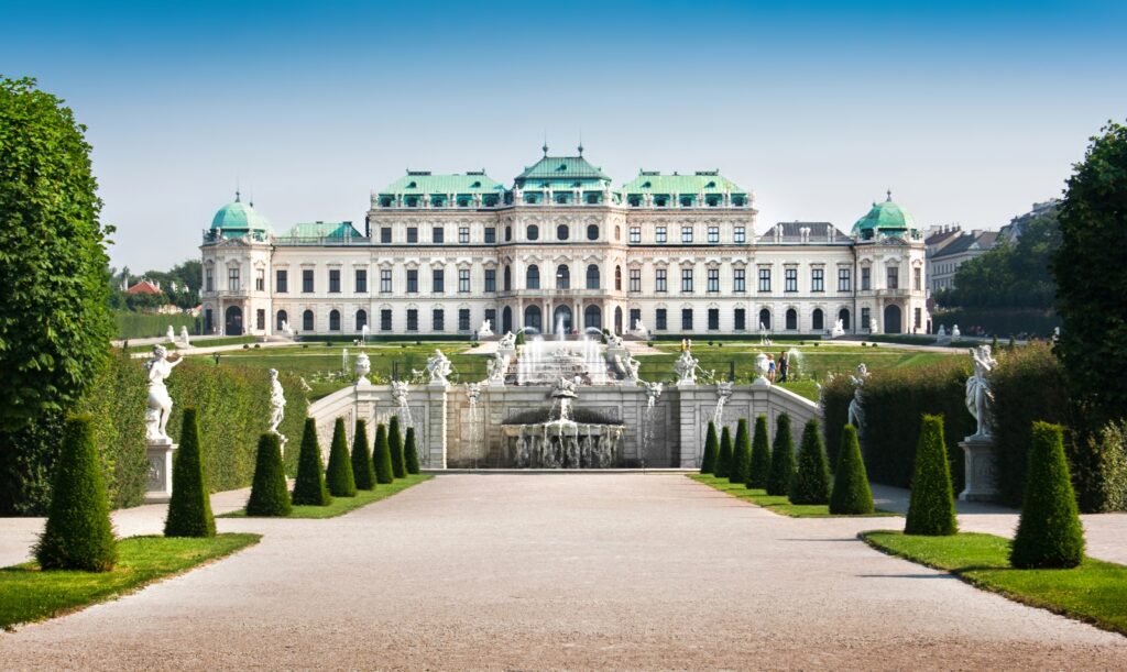 Schloss Belvedere in Wien, ein prächtiges Barockschloss mit eleganter Fassade, umgeben von symmetrischen Gärten und reflektierendem Wasserbecken.