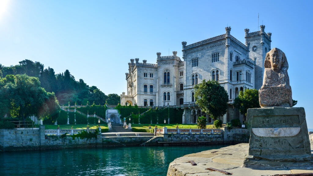 Schloss Miramare in Triest, Italien, umgeben von grünen Gärten.