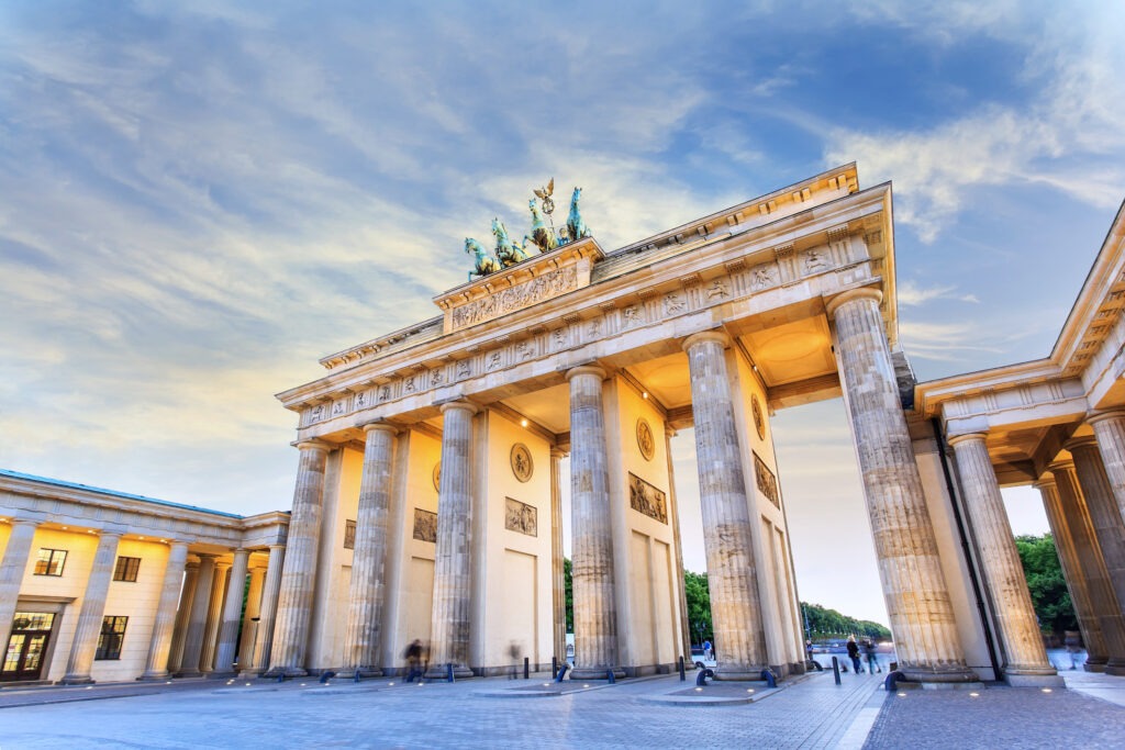 Das Brandenburger Tor in Berlin bei Nacht, beeindruckend beleuchtet und umgeben von einer belebten Atmosphäre.