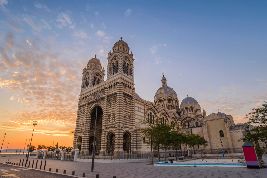 Cathédrale de la Major in Marseille, Frankreich, bei Sonnenuntergang mit beeindruckender byzantinisch-romanesker Architektur und Blick auf das Mittelmeer.