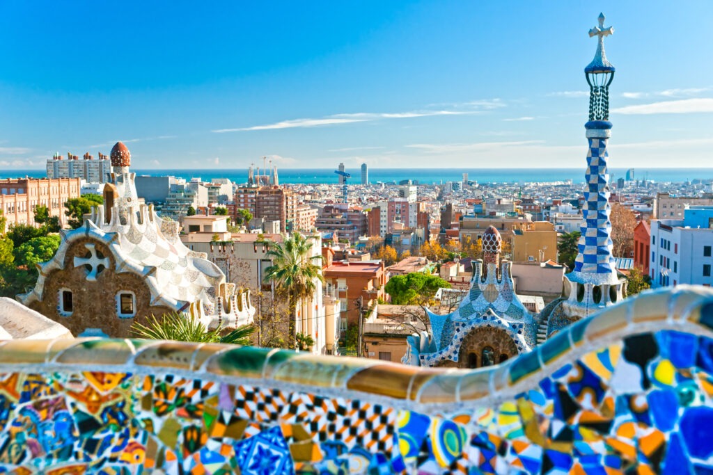 Park Güell in Barcelona, Spanien, mit bunten Mosaiken, geschwungenen Bänken und Blick über die Stadt.