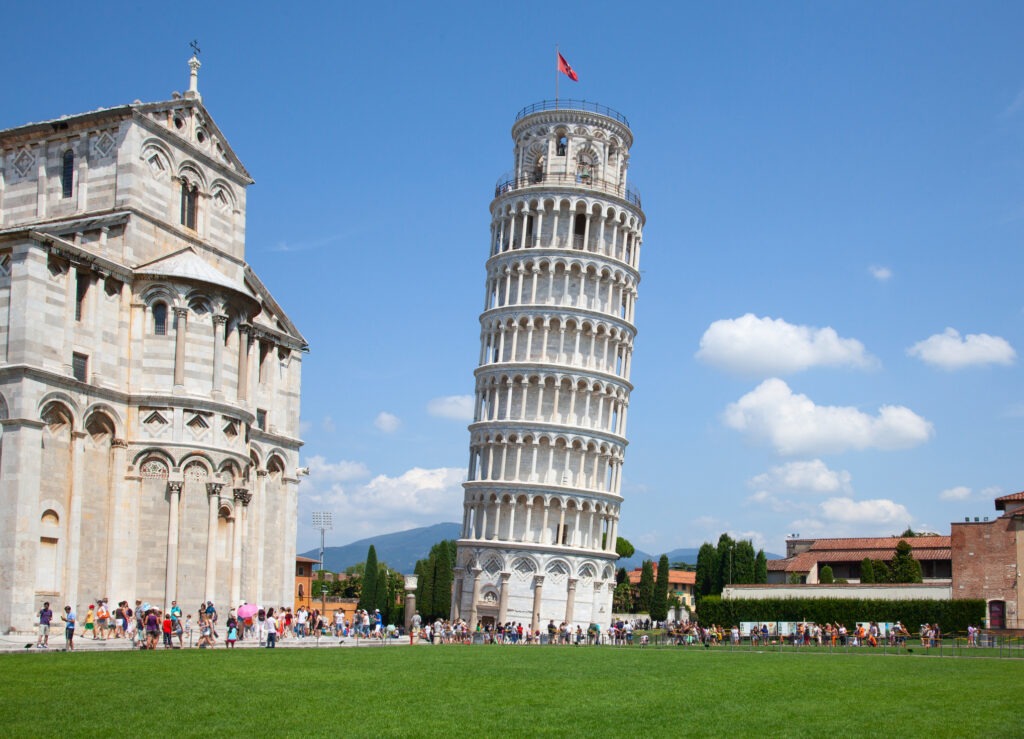 Der Schiefe Turm von Pisa, Italien, mit seiner markanten Neigung und historischer Marmorfassade bei blauem Himmel.