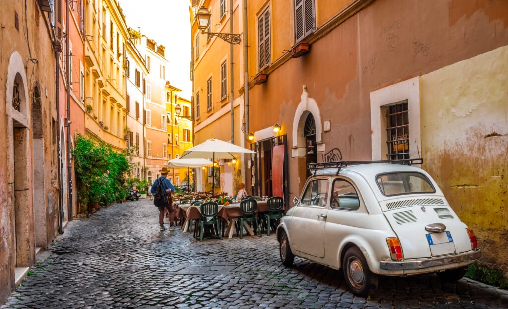 Charmante Gasse in Trastevere, Rom, Italien, mit Kopfsteinpflaster, bunten Fassaden und gemütlichen Restaurants.